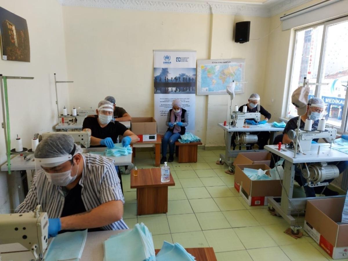 Afgan sığınmacılar g&ouml;n&uuml;ll&uuml; olarak maske &uuml;retiyor