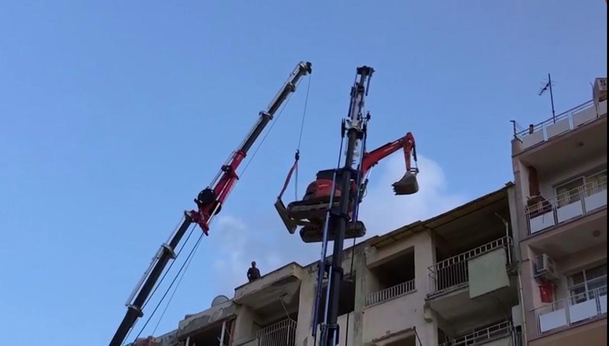 Yıkımda kullanılacak iş makinesi, vin&ccedil;le 6 katlı binanın &uuml;zerine &ccedil;ıkarıldı