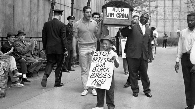 Demonstrators carry a mock coffin labeled 