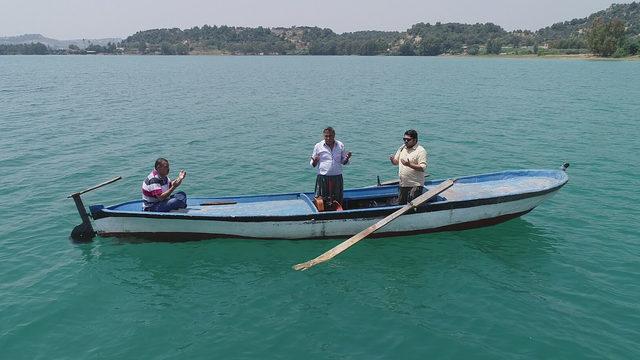 Su altında kalan mezarlığa sandalla giderek dua ediyorlar
