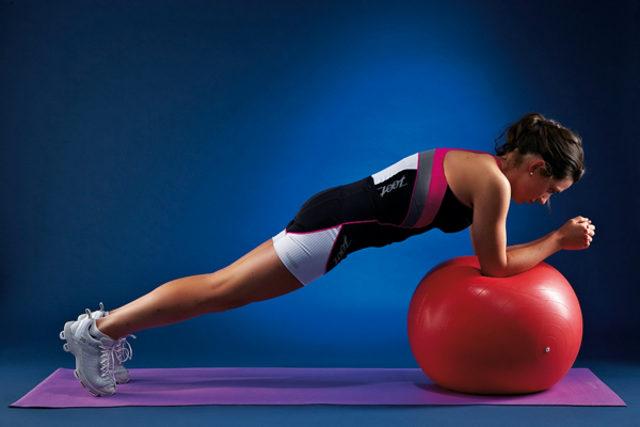 Pilates Topu ile Plank yapan kadın 