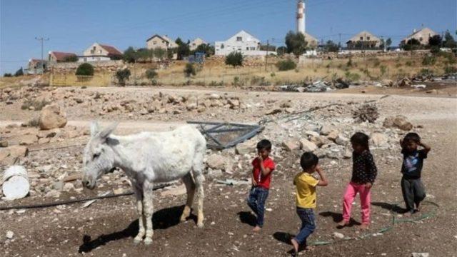 Filistinli çocuklar ve arka planda görünen Yahudi yerleşimleri