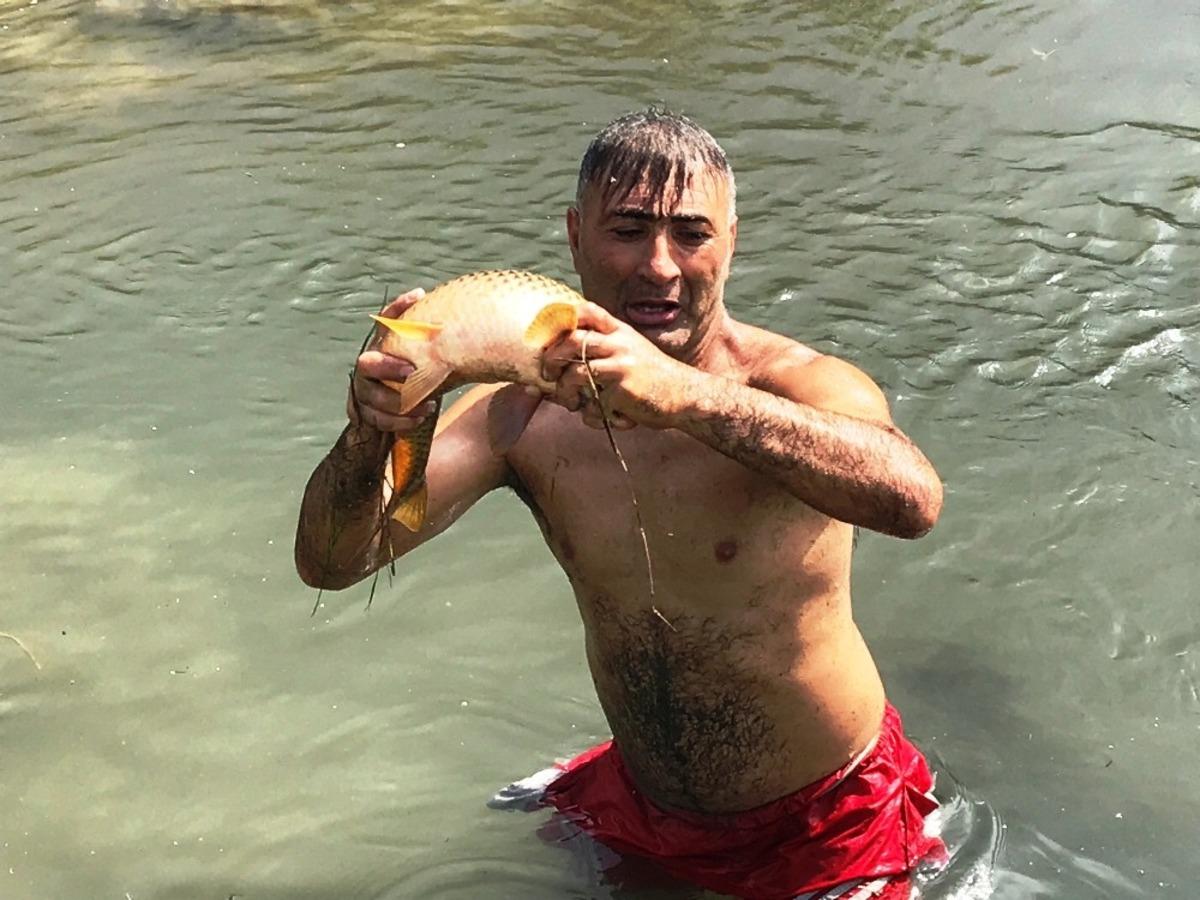 &Ccedil;ıplak elle balık tutan adamın yeteneği şaşırttı