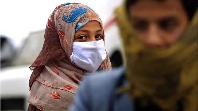 A Yemeni woman wears a face mask