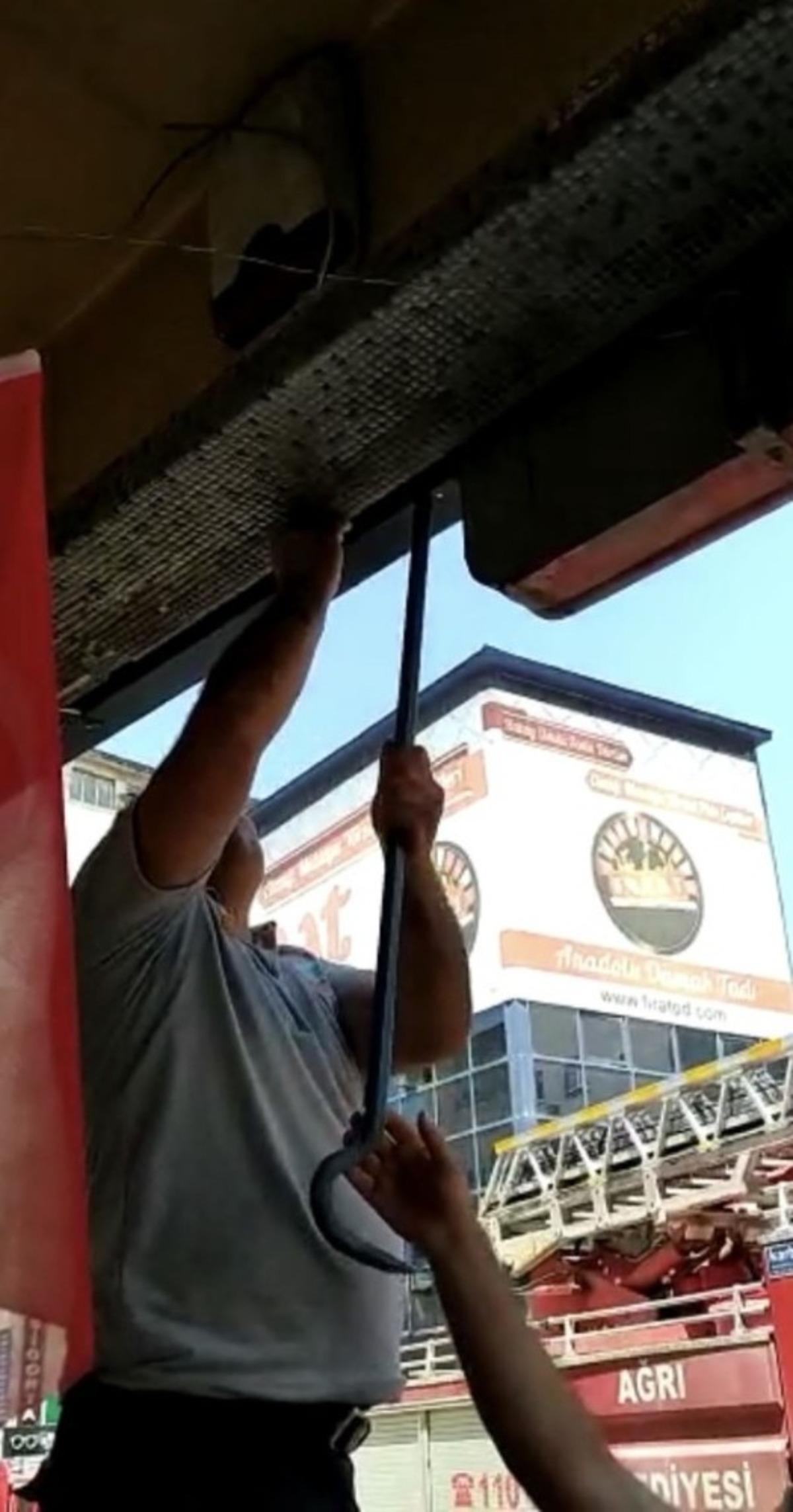 D&uuml;kkan tabelasına sıkışan g&uuml;vercin itfaiye tarafından kurtarıldı