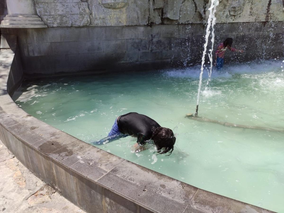 Sıcaktan bunalan &ccedil;ocuklar tehlikeye aldırış etmeden s&uuml;s havuzunda serinliyor
