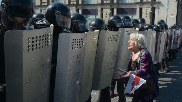 polisle karşı karşıya gelen kadın bir protestocu