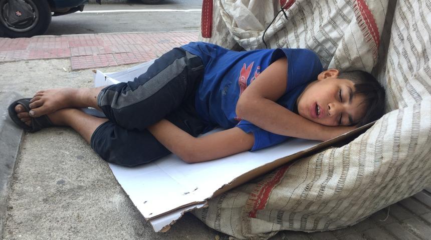 Atık kağıt toplarken uyuyakaldı! Savaşın çocuğu görenlerin içini sızlattı