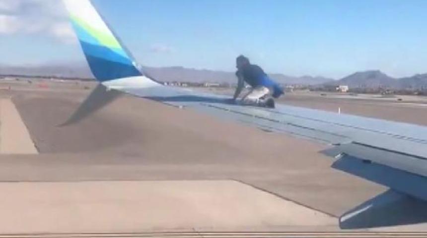 Şaşkına çeviren olay! Uçağın kanadına çıktı, çoraplarını çıkardı