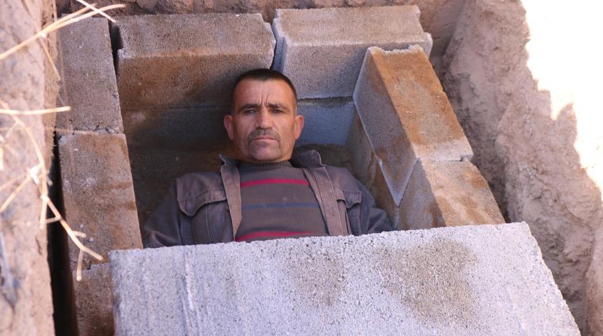 Koronavirüse dikkat çekmek için kendi kazdığı mezara girdi