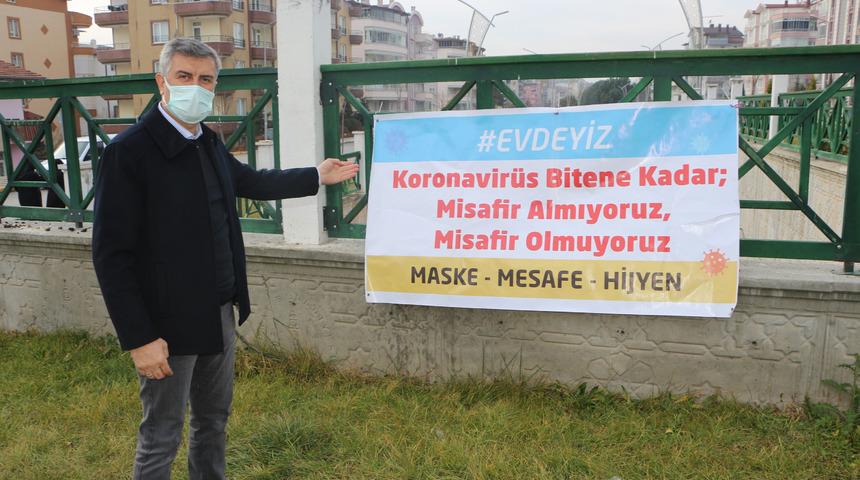 Tokat'ta mahalle muhtarı kavşağa 'Evde kal' afişi astı