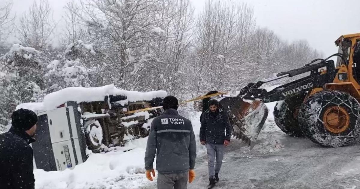 Karlı yolda yan yatan minib&uuml;s&uuml; iş makinesi ile kurtardılar