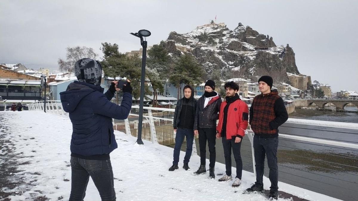 Beyaz &ouml;rt&uuml;yle kaplanan tarihi kaleye karşı hatıra fotoğrafı
