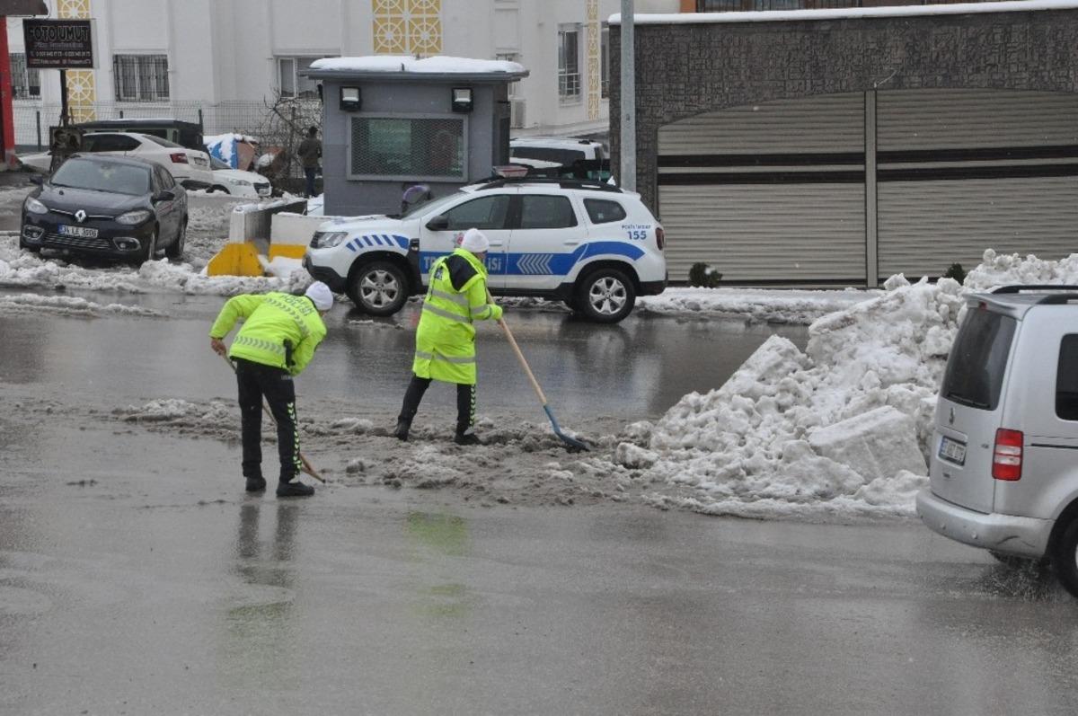 Polisler ellerine k&uuml;rek aldı, yolda biriken kar birikintilerini temizledi