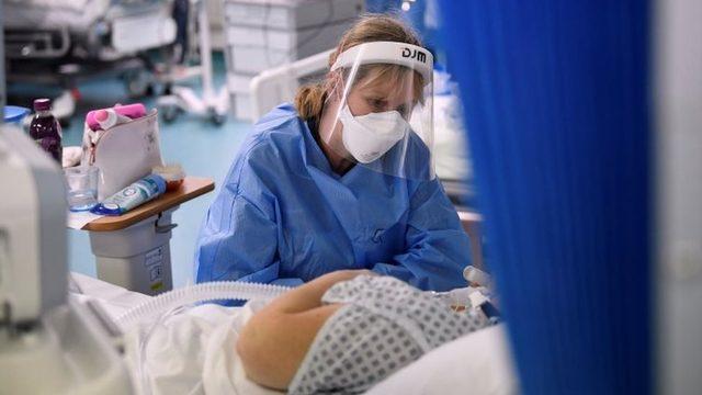 A nurse wearing a face mask attending to a patient