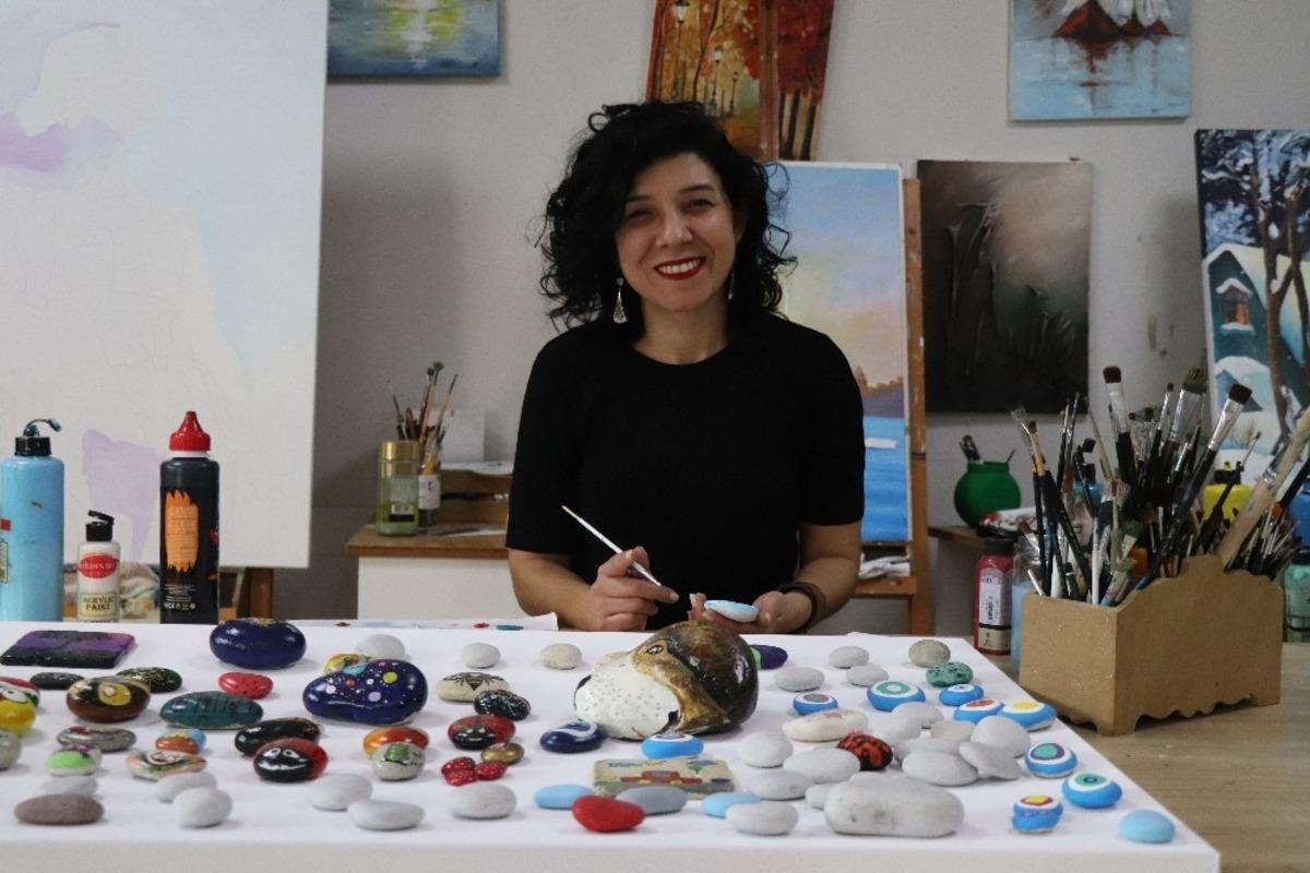 Tuvalde g&ouml;rd&uuml;ğ&uuml; resimleri minik doğal taşlar &uuml;zerine nakşetti