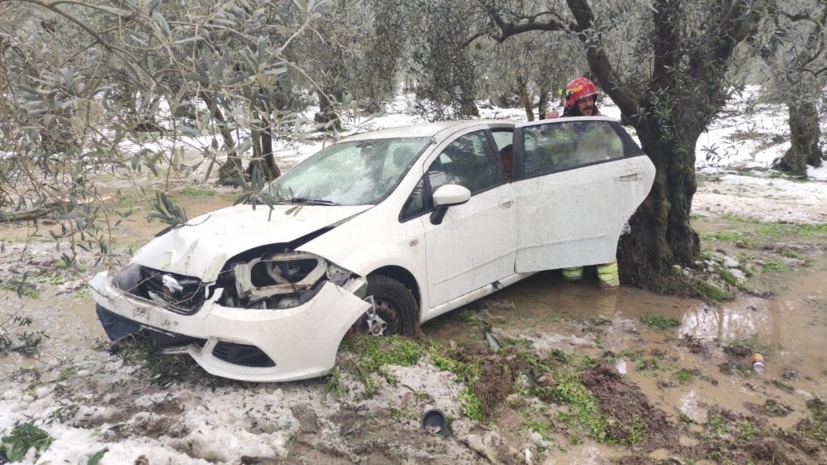 Otomobil zeytinliğe u&ccedil;tu, itfaiyeci yaşlı kadını sırtında ambulansa taşıdı