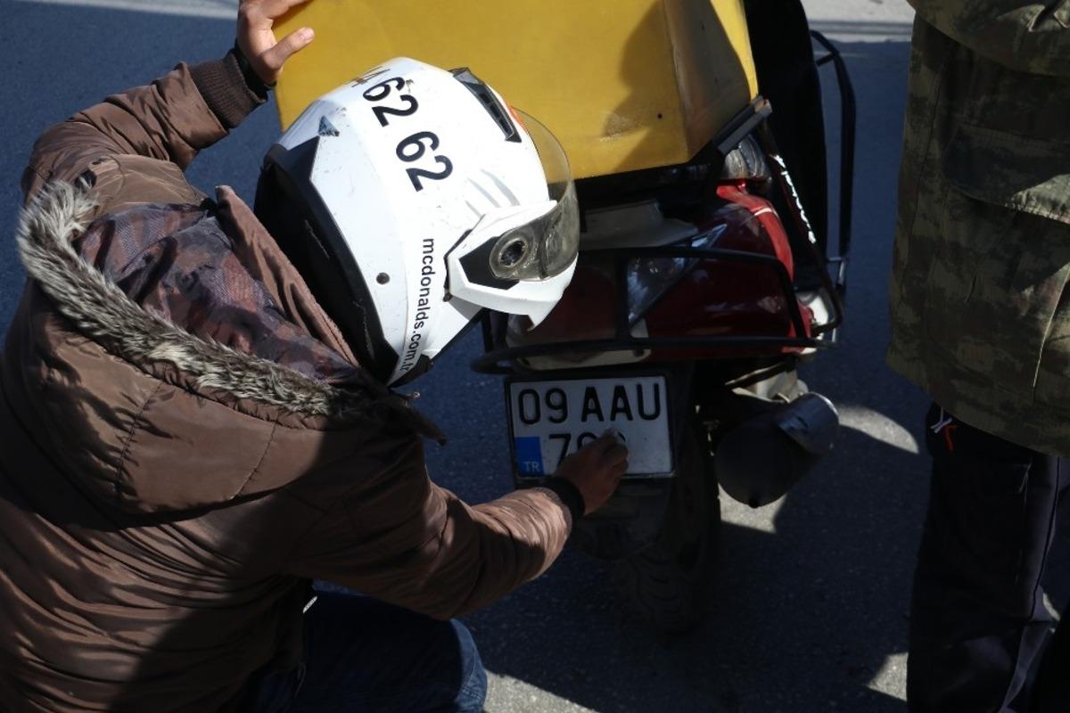 Trafik timleri kuryelerin kirlenen plakalarını mendille temizletti