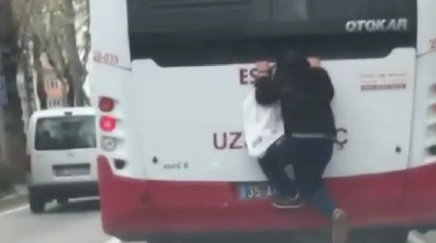 İzmir'de tehlikeli yolculuk! Hareket halindeki otobüse tutunarak canını hiçe saydı