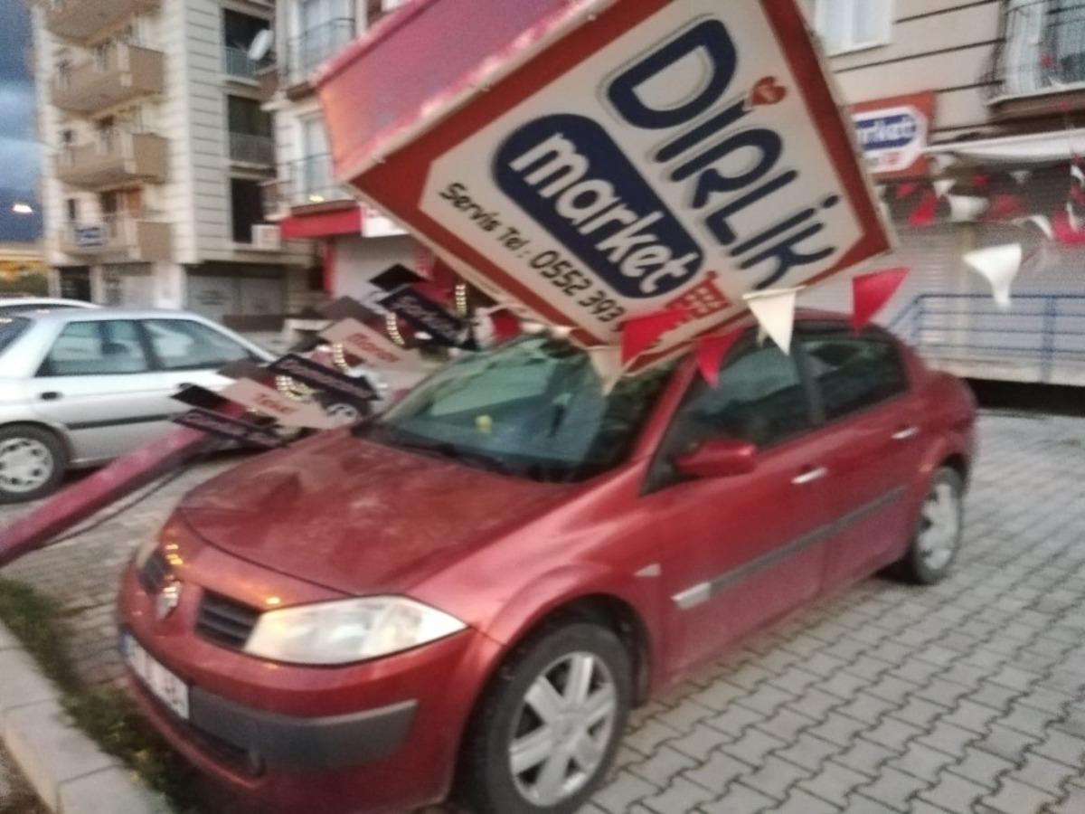 Hatay&rsquo;da fırtınada reklam direği otomobilin &uuml;zerine devrildi