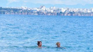 Karlı dağ manzarası eşliğinde denize girip güneşlendiler!