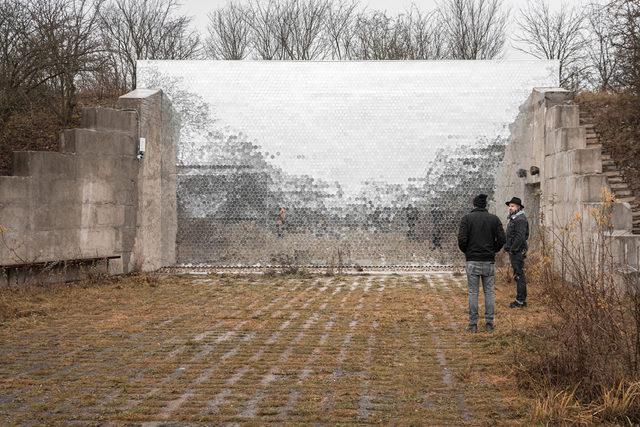 People standing outside next to a reflective wall