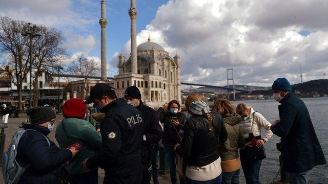 İstanbul'da ilan edilen kapanma günlerinde bir grup Rus turistin pasaportlarını kontrol eden polis