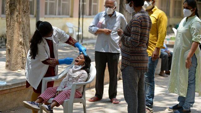 Hindistan'da bir çocuğa koronavirüs testi yapılıyor