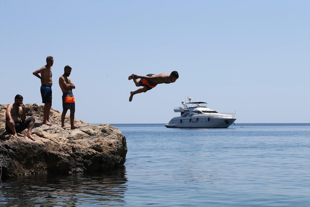 Antalya'da sıcak havada bunalanlar serinlemek i&ccedil;in sahilleri tercih etti