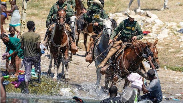 US Border Patrol agents on horseback tries to stop Haitian migrants from entering an encampment on the banks of the Rio Grande near the Acuna Del Rio International Bridge in Del Rio, Texas on September 19, 2021