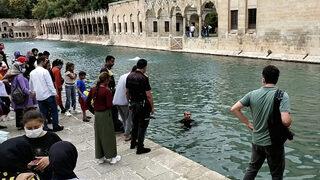 Şanlıurfa'da şaşırtan olay! Herkesin gözü önünde Balıklıgöl’e atlayıp yüzdü