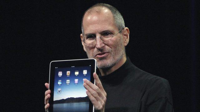 Steve Jobs bir iPad tutarken
