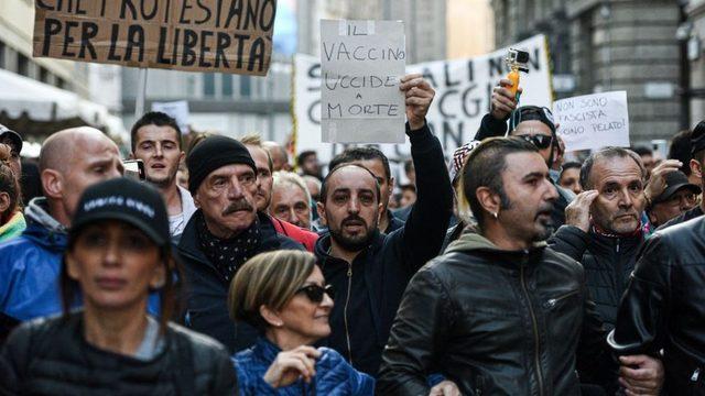 Covid sertifikası karşıtı bir gösteride 'Aşı öldürür' yazılı bir kağıt taşınıyor