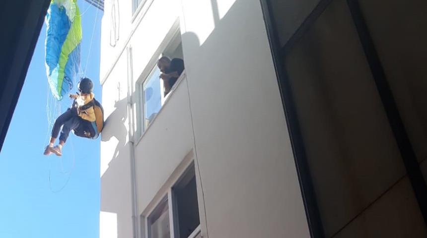 Antalya'da ilginç olay! Rus turist, paraşütle çatıda asılı kaldı