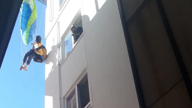 Antalya'da ilginç olay! Rus turist, paraşütle çatıda asılı kaldı