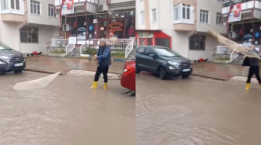 Suyla dolan caddeye 'ağ atarak' tepki gösterdi