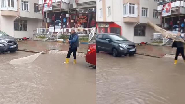 Suyla dolan caddeye 'ağ atarak' tepki gösterdi