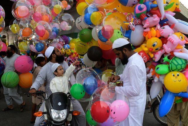 Pakistan'ın Karaçi şehrinde bir çocuk, Ramazan Bayramı namazının ardından bir balonu işaret ediyor.