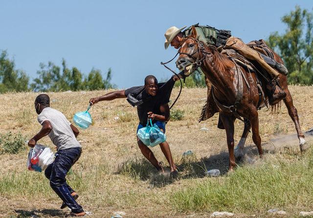 Eylül ayında ABD'nin Texas eyaletinde Haitili göçmenlerin ülkeye girişlerini engellemeye çalışan atlı sınır görevlilerine ait bu fotoğraf, bir soruşturmaya neden oldu. Görüntüler politikacılar tarafından kınanırken, Amerika'nın kölelik dönemiyle karşılaştırmalara yol açtı.