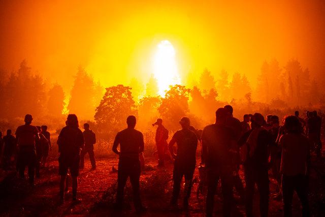 Yunanistan'da Eğriboz Adası'nı etkisi altına alan orman yangınlarında, gönüllü halk itfaiye ekiplerine yardım etmek için bekliyor.