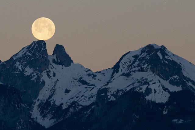 Ay sanki İsviçre tepelerinde dengede duruyor