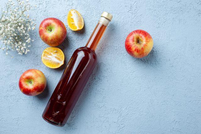 1643649237_top_view_apple_vinegar_bottle_white_background_juice_fruit_color_photo_fresh_drink_sour_food