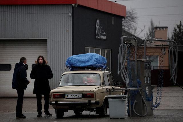 FILE PHOTO: Local residents are seen refueling at gas station after Russian President Vladimir Putin authorized a military operation in eastern Ukraine, in Mariupol