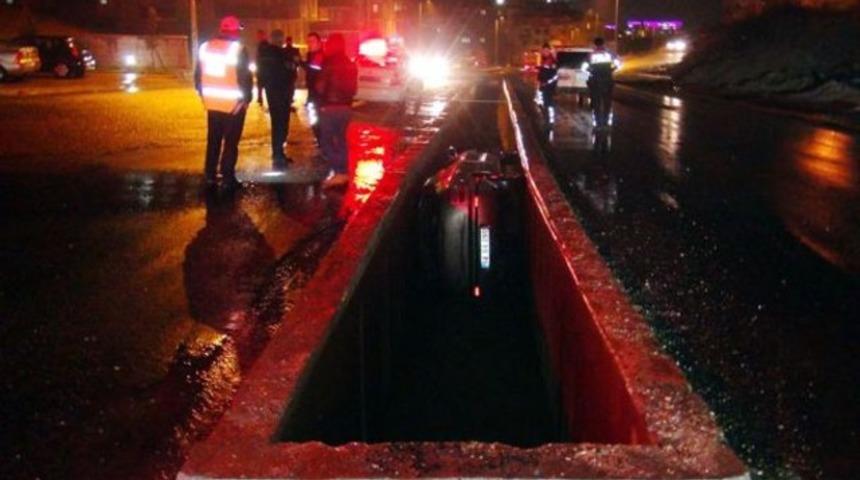 Otomobil yol ortasındaki su kanalına düştü
