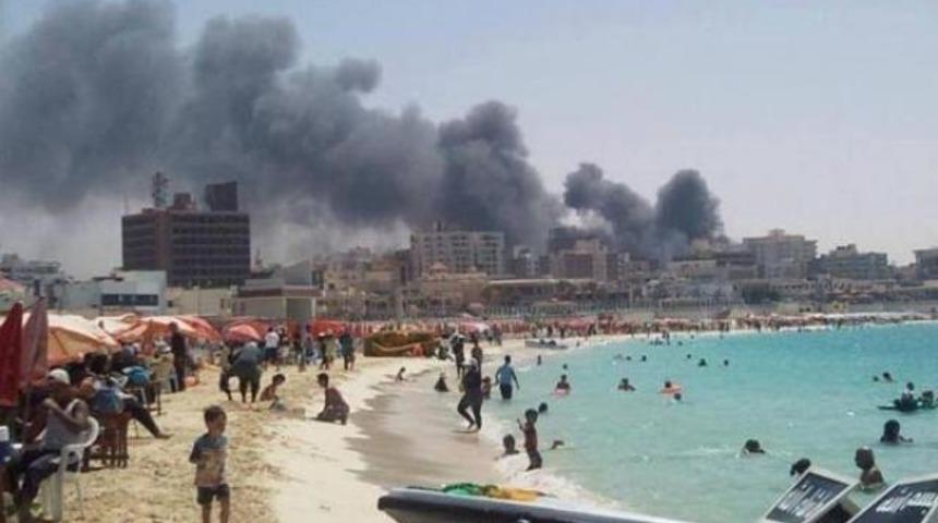 Bombaların gölgesinde denize giriyorlar