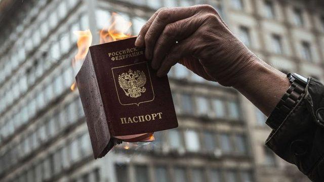 Savaş karşıtı protestolarda Rusya pasaportunu yakan bir kişi.