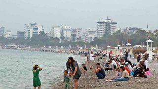 Havaya aldırmayıp akın ettiler! Bayramın tadını Antalya'nın Konyaaltı Sahili'nde çıkardılar