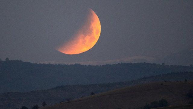 Süper kanlı Ay, Kuzey Makedonya Cumhuriyeti'nde tepelerin üzerinden batarken görünüyor