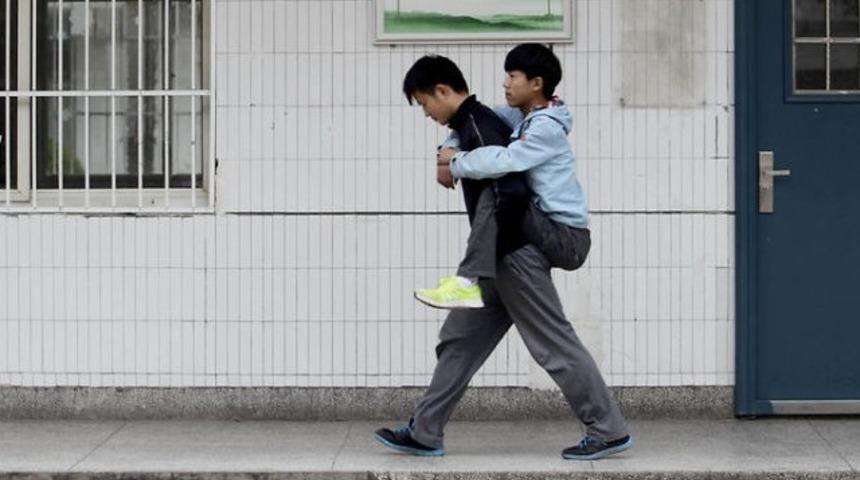 Engelli arkadaşını son 3 yıldır okula sırtında g&ouml;t&uuml;r&uuml;yor