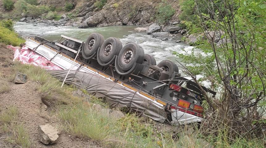 Artvin'de un yüklü tırın dorsesi dere yatağına devrildi